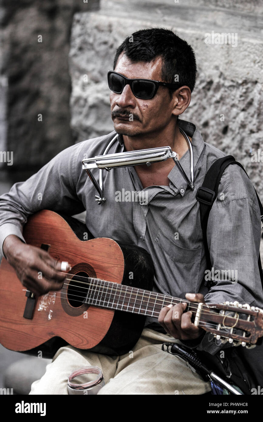 Busker ciego tocando armónica y guitarra en Quito, Ecuador, Sudamérica  Fotografía de stock - Alamy