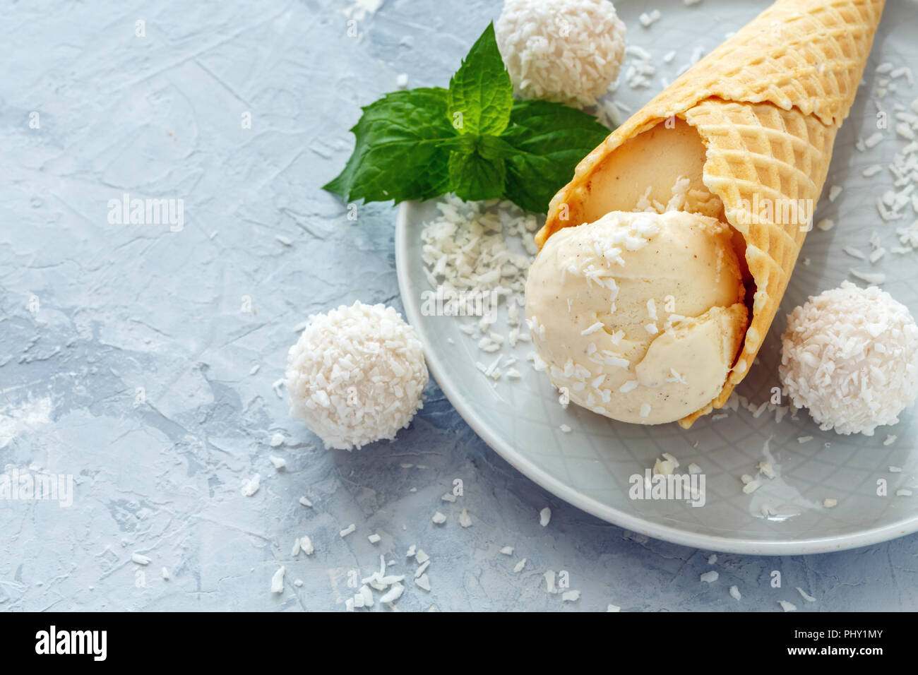 Cono con helado de coco y coco trufas. Foto de stock