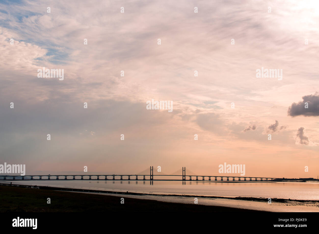 Vista del segundo Severn Crossing (Puente Príncipe de Gales) desde el lado Inglés (antiguo pasaje, Aust) durante la marea baja. Por la tarde. La puesta de sol. En el verano. Foto de stock