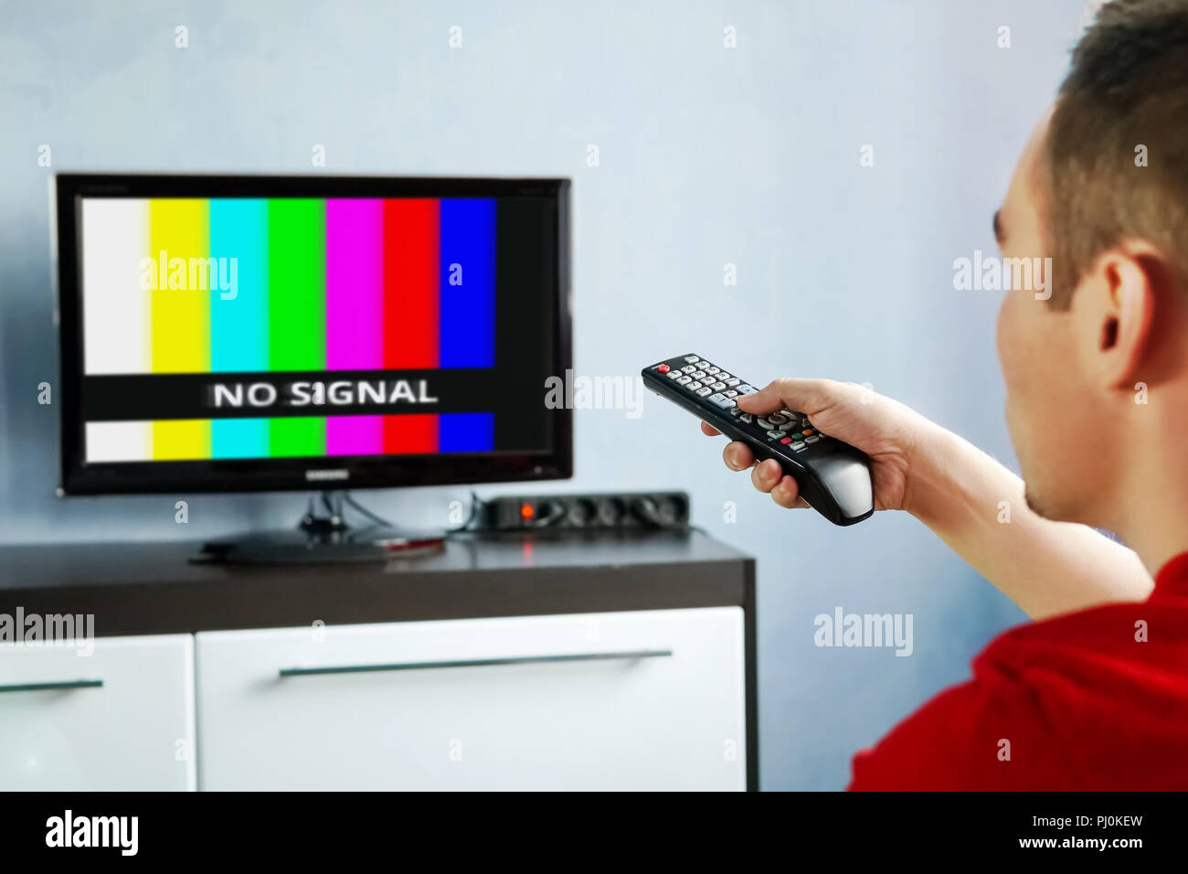 Control remoto en mano delante del televisor. Couch Potato. Banner de  pantalla sin señal Fotografía de stock - Alamy
