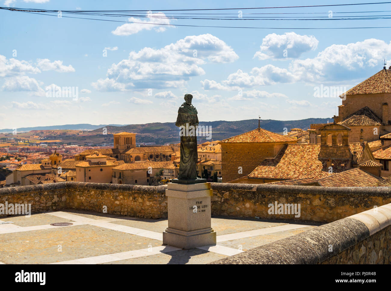 Estatua del poeta y religioso Fray Luis de León, en la parte superior del casco antiguo de la ciudad de Cuenca, España. Casas y montañas en el fondo. Foto de stock