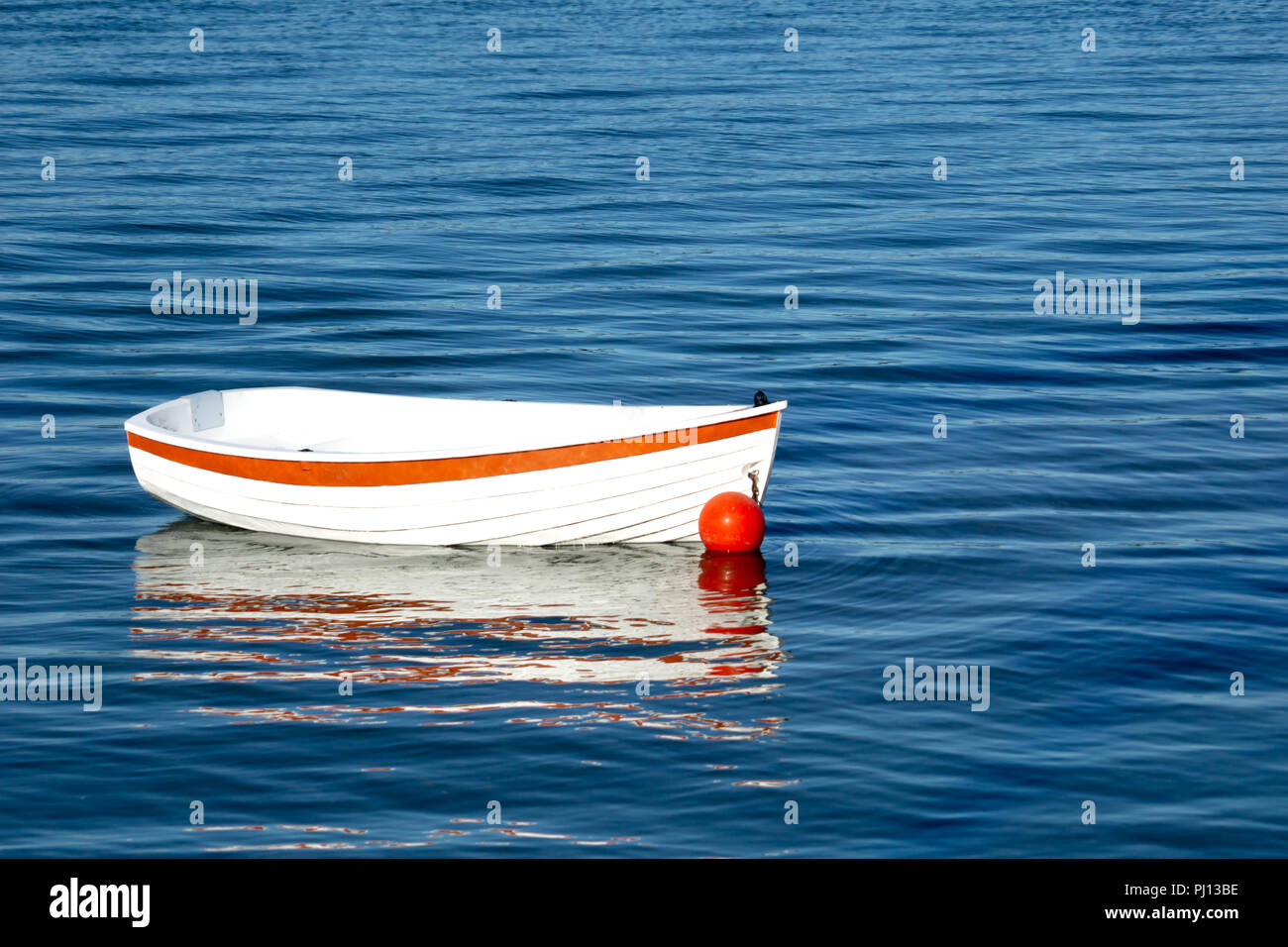 Bote pequeño blanco con líneas de clinker y franja naranja en agua azul  oscuro Fotografía de stock - Alamy