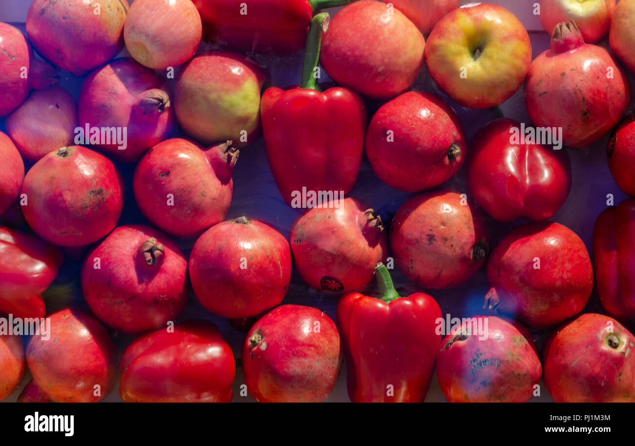 Las granadas y las manzanas fondo rojo Foto de stock