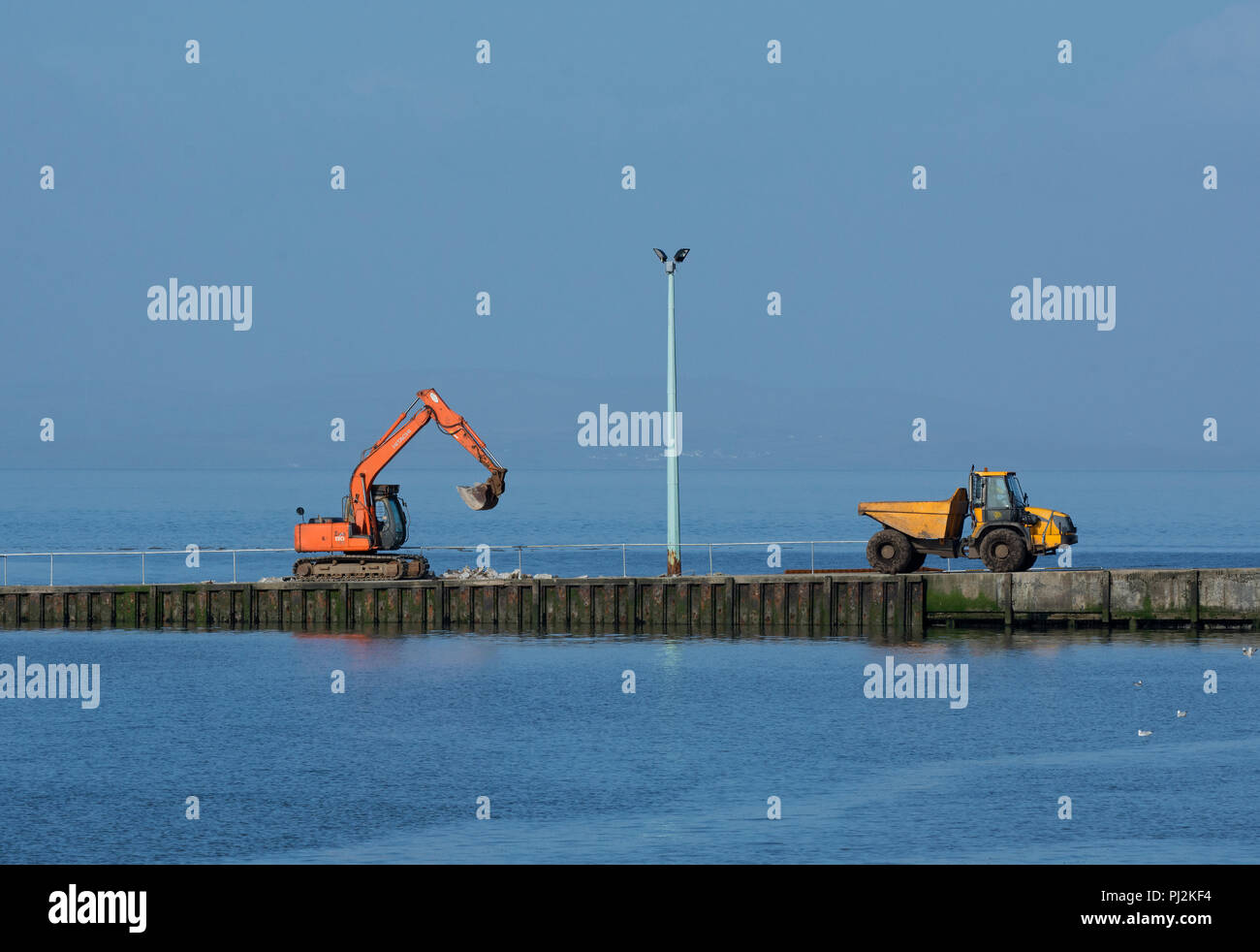 Construcción digger con volquete automotor en ferry grada, Knott final sobre el mar, Lancashire, UK Foto de stock