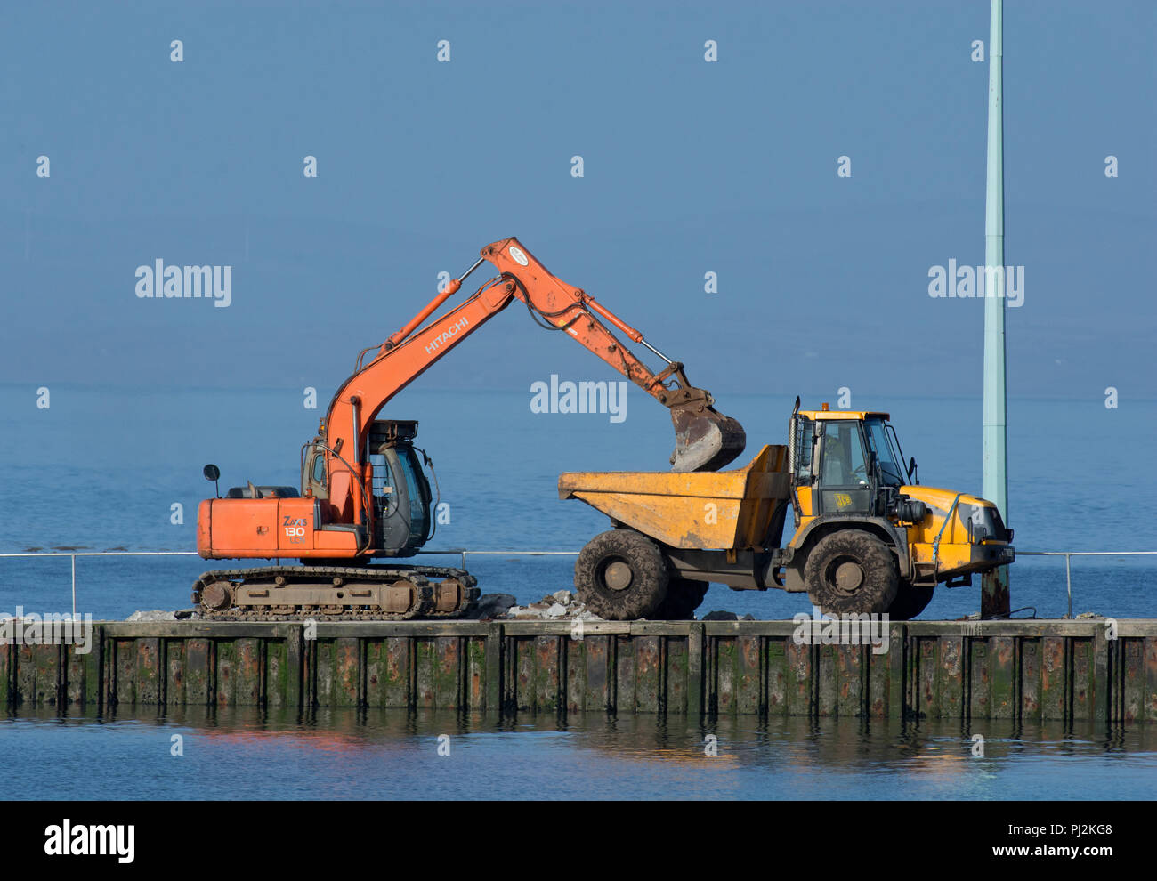 Construcción digger con volquete automotor en ferry grada, Knott final sobre el mar, Lancashire, UK Foto de stock