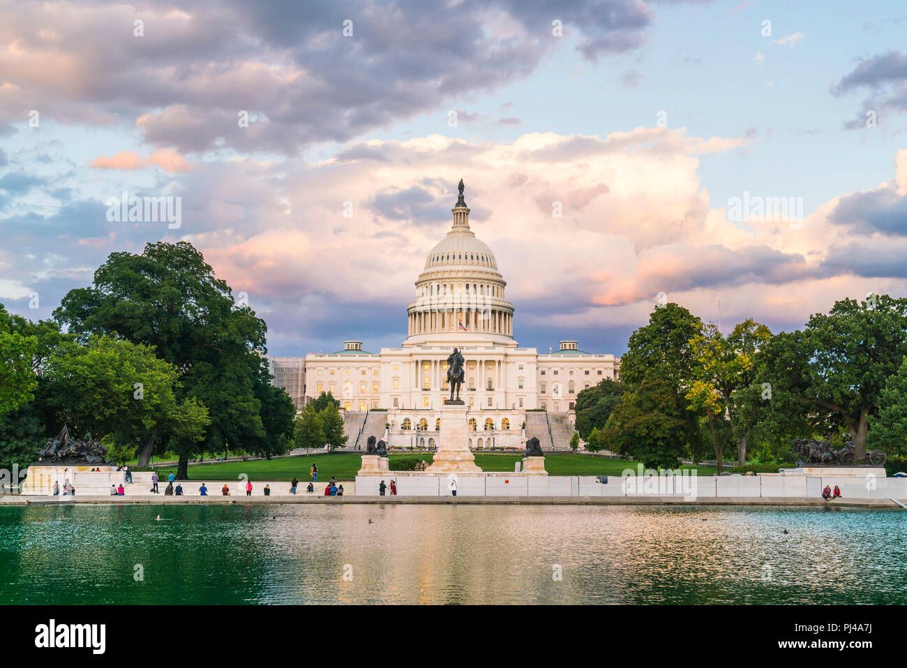 El edificio del Capitolio de los Estados Unidos al atardecer con la celebración del reflejo en el agua. Foto de stock