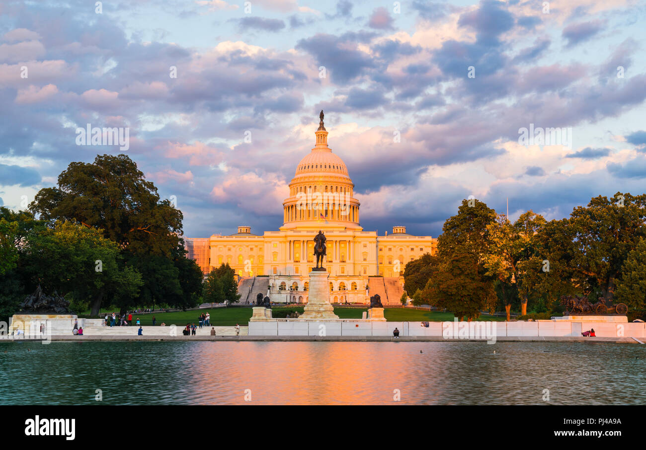 El edificio del Capitolio de los Estados Unidos al atardecer con la celebración del reflejo en el agua. Foto de stock