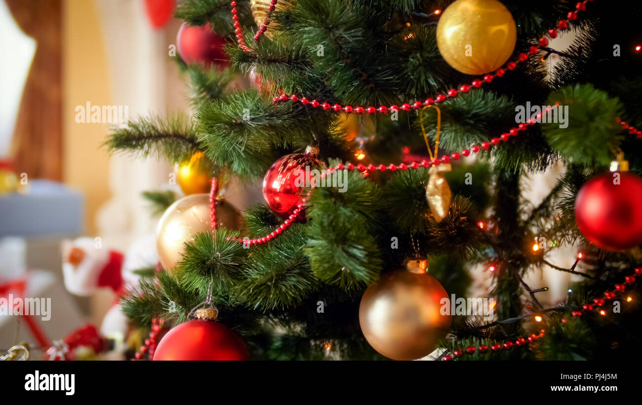 Closeup imagen de dorado y rojo chucherías colgando de abeto decorado para la Navidad Foto de stock