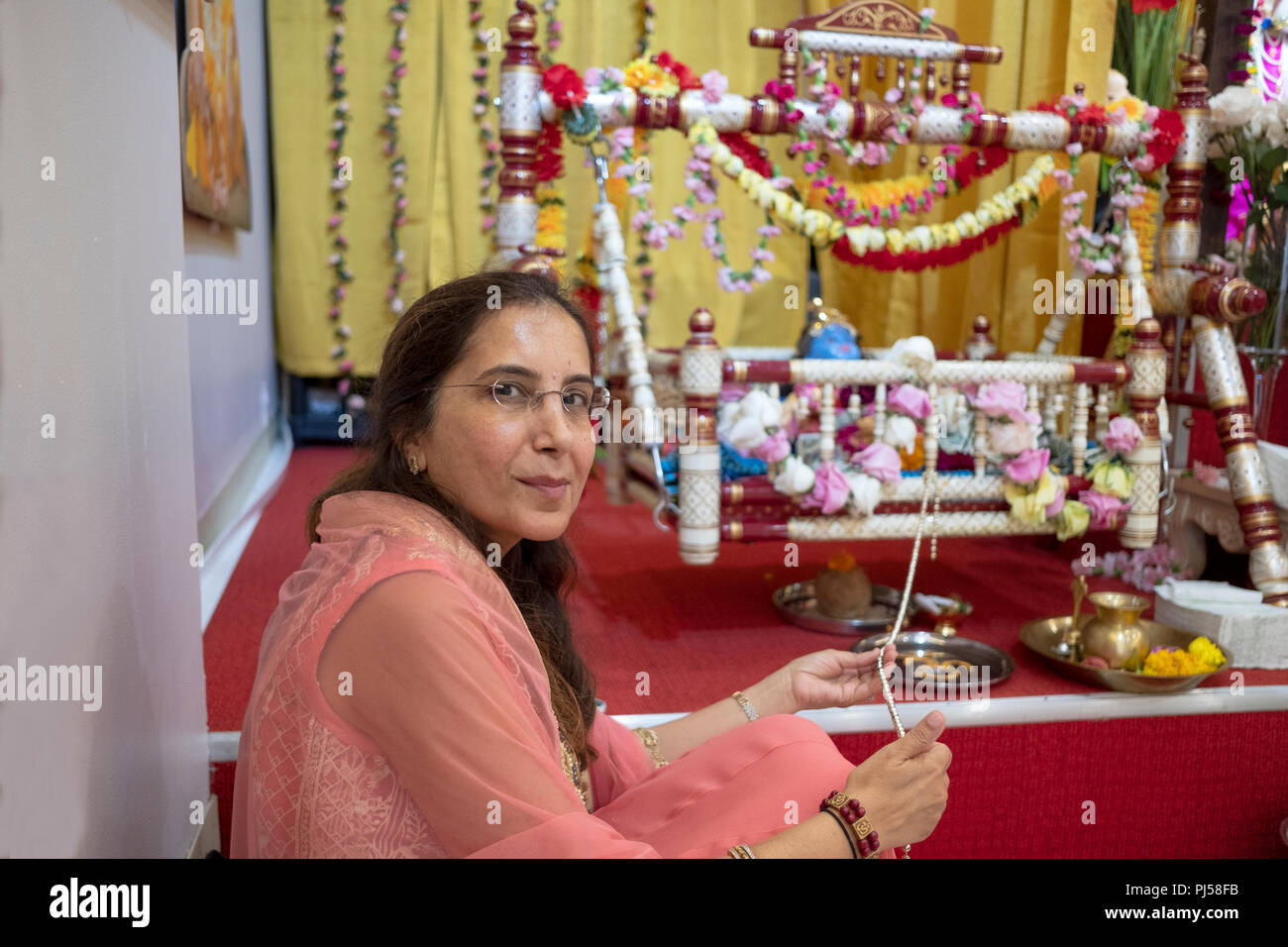 Una atractiva mujer de mediana edad en un templo hindú para la celebración de Janamashthmi en Glen Oaks, en el barrio de Queens, NY. Foto de stock