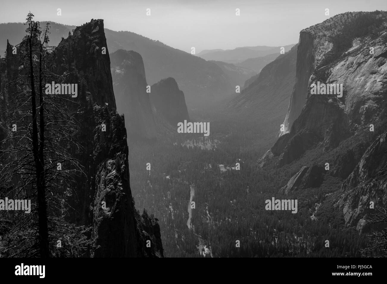 Una vista mirando hacia abajo al valle de Yosemite con el Capitan de la derecha en el Parque Nacional Yosemite. El humo de los incendios silvestres perdura en el valle. Foto de stock