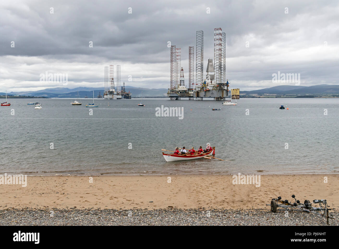 Plataformas de exploración petrolera amarrados en Cromarty Firth cerca Cromarty Highland Scotland Reino Unido con bote a remo Cromba Foto de stock