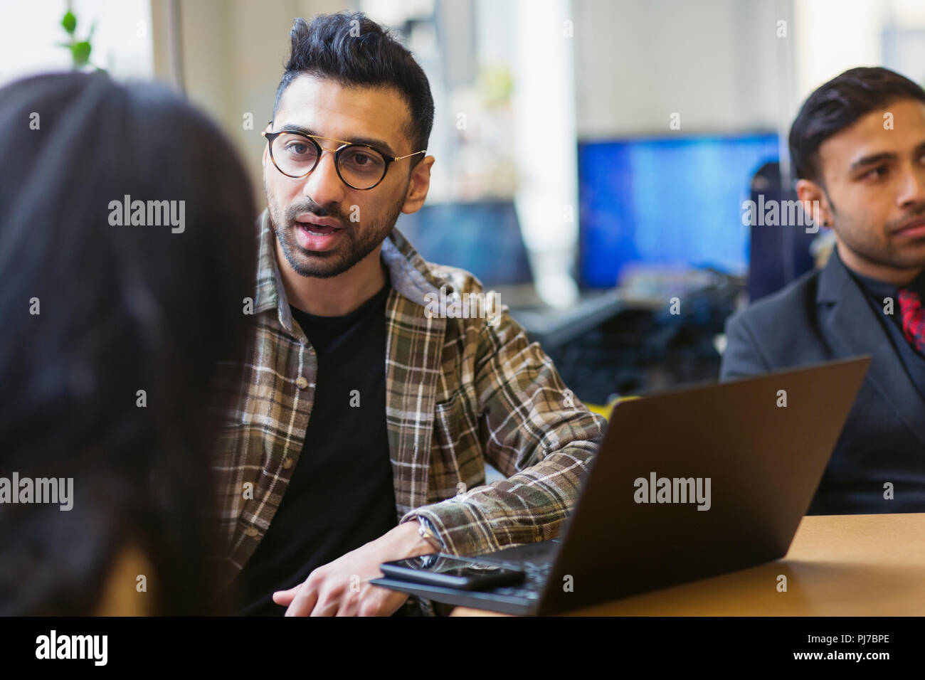 Empresario en portátil hablando con su colega Foto de stock