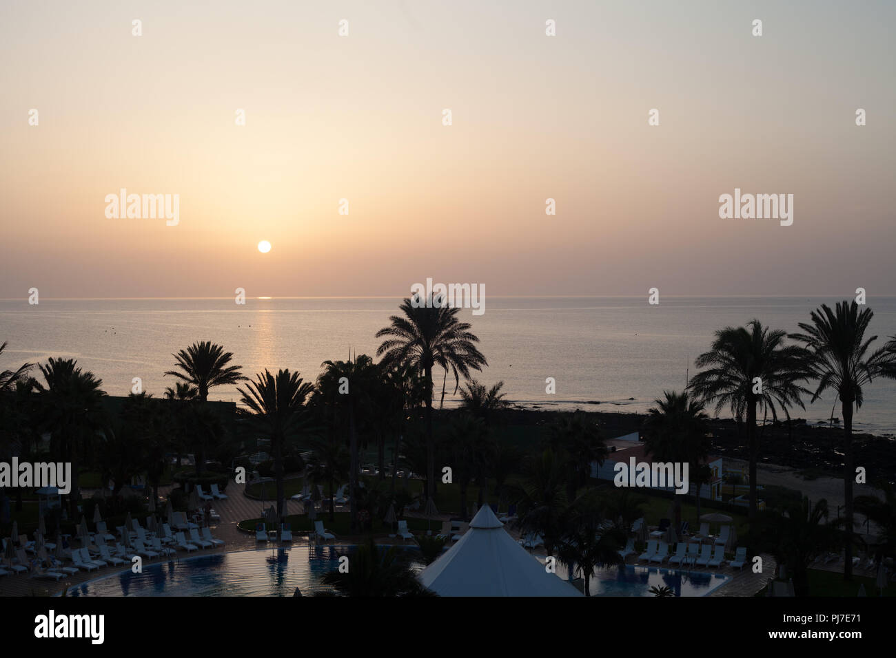 Puesta de sol sobre el Atlántico desde la ventana del hotel, cerca de Corralejo, Fuerteventura, Islas Canarias, España Foto de stock