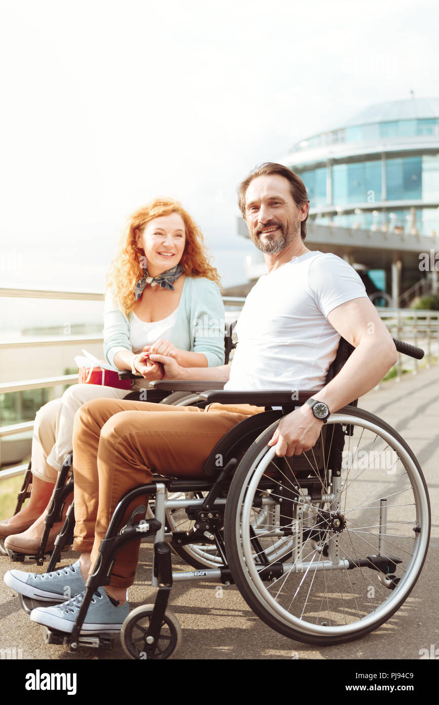 Pareja de apoyo en sillas de ruedas, sonriendo alegremente Fotografía de  stock - Alamy