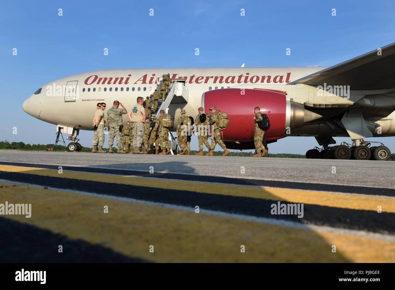 Aviadores estadounidenses de la 169ª Ala de caza de la Guardia Nacional Aérea de Carolina del Sur en la base de la Guardia Nacional conjunto McEntire, Carolina del Sur, junta un civil contratado aviones de transporte grandes, 11 de julio de 2018. La Guardia Nacional Aérea de Carolina del Sur la 169ª Ala de caza es un despliegue de casi 300 aviadores y aproximadamente una docena de F-16 Block 52 combates Falcon cazas a la 407ª Aire grupo expedicionario en el suroeste de Asia en apoyo de una fuerza expedicionaria aérea rotación. Foto de stock