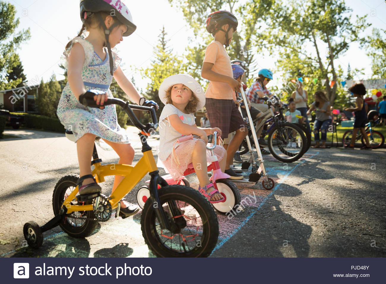 En las bicicletas de niños listos para la carrera en la línea de partida en el verano barrio block party Foto de stock