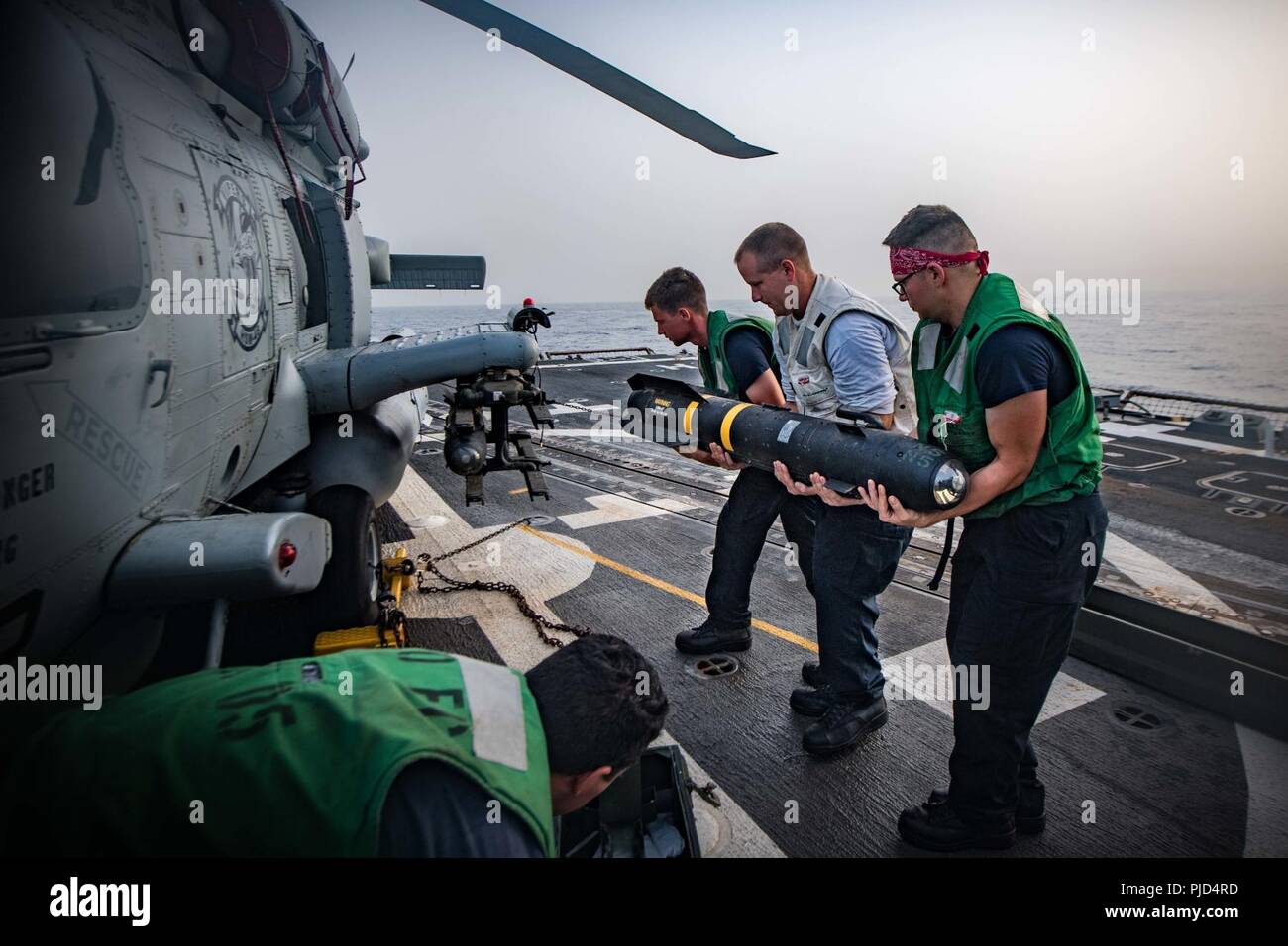 5ª Flota de EE.UU. ZONA DE OPERACIONES (18 de julio de 2018, los marineros de la Marina de EE.UU.), asignada a las "víboras" huelga marítimo escuadrón de helicópteros (HSM) 48, cargar un misil AGM-114 Hellfire en un helicóptero MH-60 Seahawk R en la cubierta de vuelo del misil guiado por el destructor USS Jason Dunham (DDG 109). Jason Dunham está desplegado en los EE.UU. 5ª Flota de la zona de operaciones en apoyo de las operaciones navales para garantizar la estabilidad y la seguridad marítima en la región central, que conecta el Mediterráneo y el Pacífico a través del Océano Índico occidental y tres estratégicos puntos críticos. Foto de stock