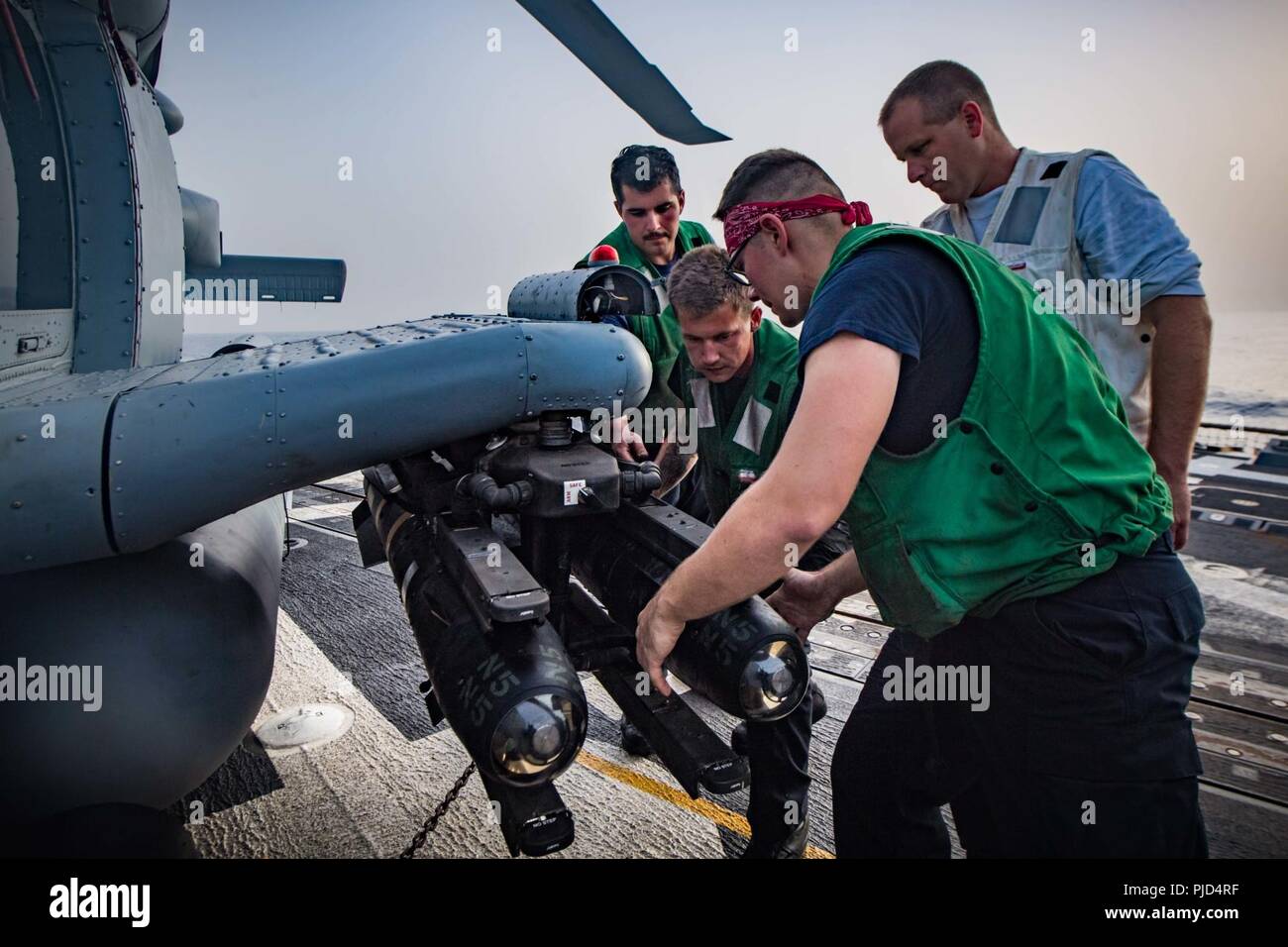 5ª Flota de EE.UU. ZONA DE OPERACIONES (18 de julio de 2018, los marineros de la Marina de EE.UU.), asignada a las "víboras" huelga marítimo escuadrón de helicópteros (HSM) 48, cargar un misil AGM-114 Hellfire en un helicóptero MH-60 Seahawk R en la cubierta de vuelo del misil guiado por el destructor USS Jason Dunham (DDG 109). Jason Dunham está desplegado en los EE.UU. 5ª Flota de la zona de operaciones en apoyo de las operaciones navales para garantizar la estabilidad y la seguridad marítima en la región central, que conecta el Mediterráneo y el Pacífico a través del Océano Índico occidental y tres estratégicos puntos críticos. Foto de stock