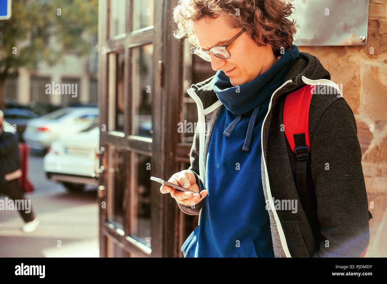 Hombre leyendo un mensaje de texto por la puerta Foto de stock