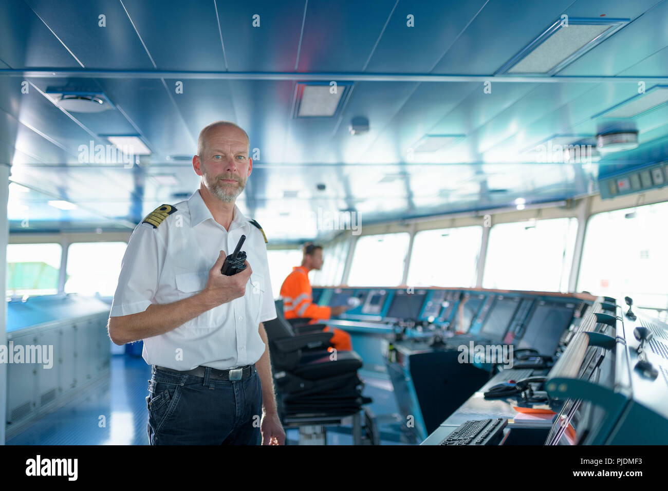 Retrato del capitán en el puente a bordo de buques en el puerto Foto de stock