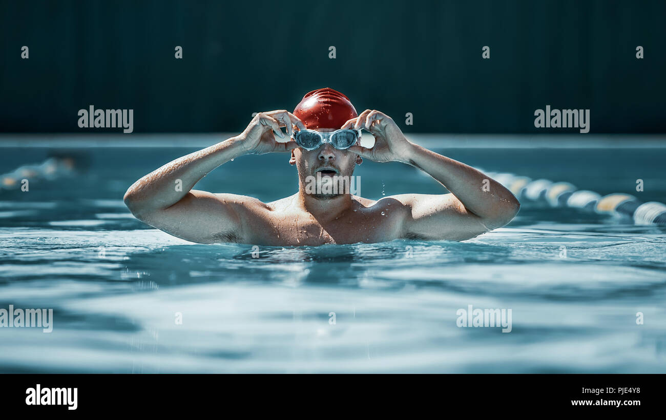 Atleta con gorra de natación y espalda de un hombre preparándose para el  ejercicio de competencia