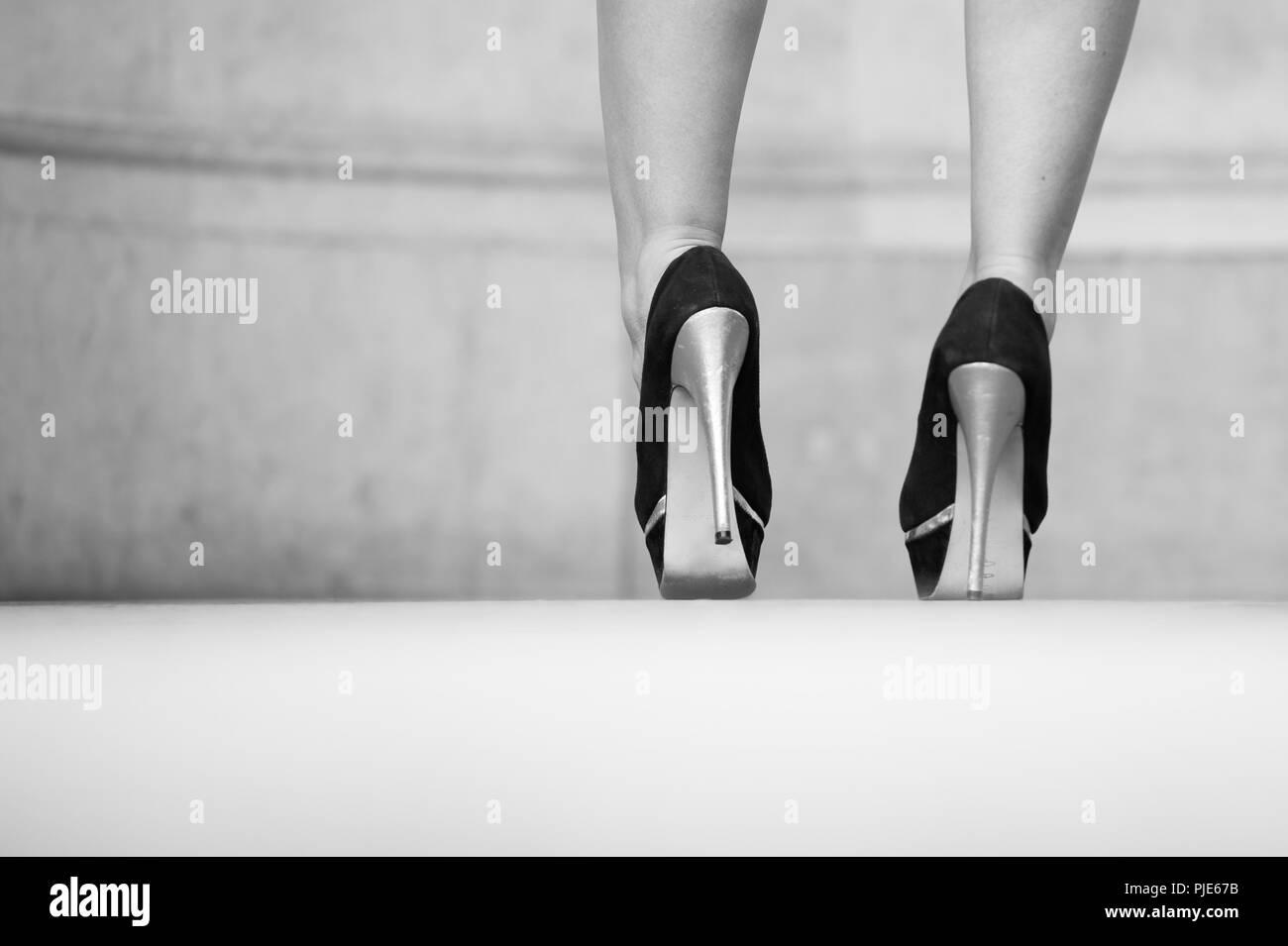 Zapatillas negras de moda en las piernas de una mujer en el estudio sobre  un fondo blanco piernas de una niña con hermosos zapatos de moda