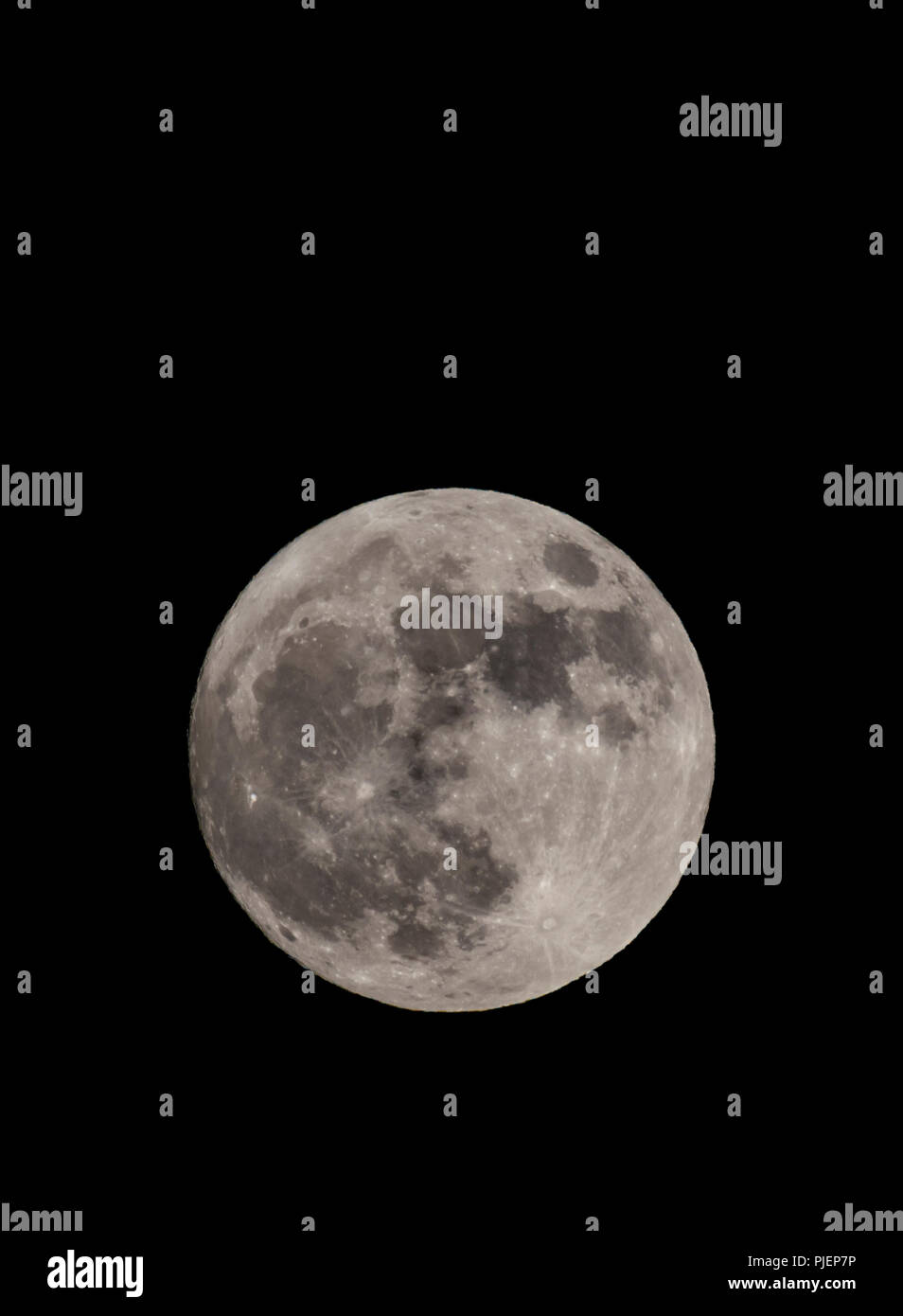 El 1 de enero de 2018 Supermoon tomada desde el sur de Inglaterra, Reino Unido. Luna llena durante la noche en invierno. Super luna vertical con espacio de copia. Foto de stock