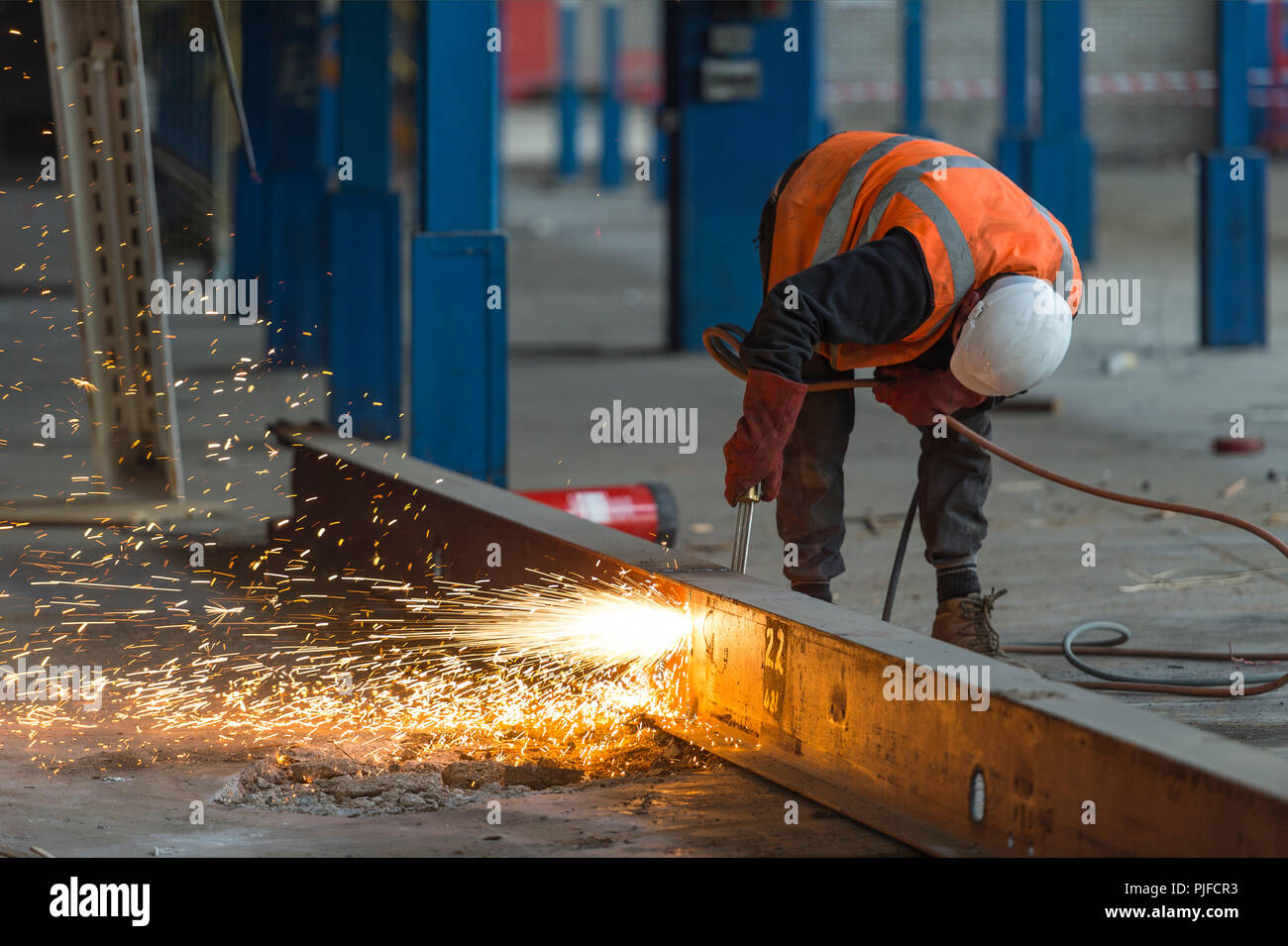 Sitio de construcción trabajador cortando una viga con un soplete de acetileno Foto de stock