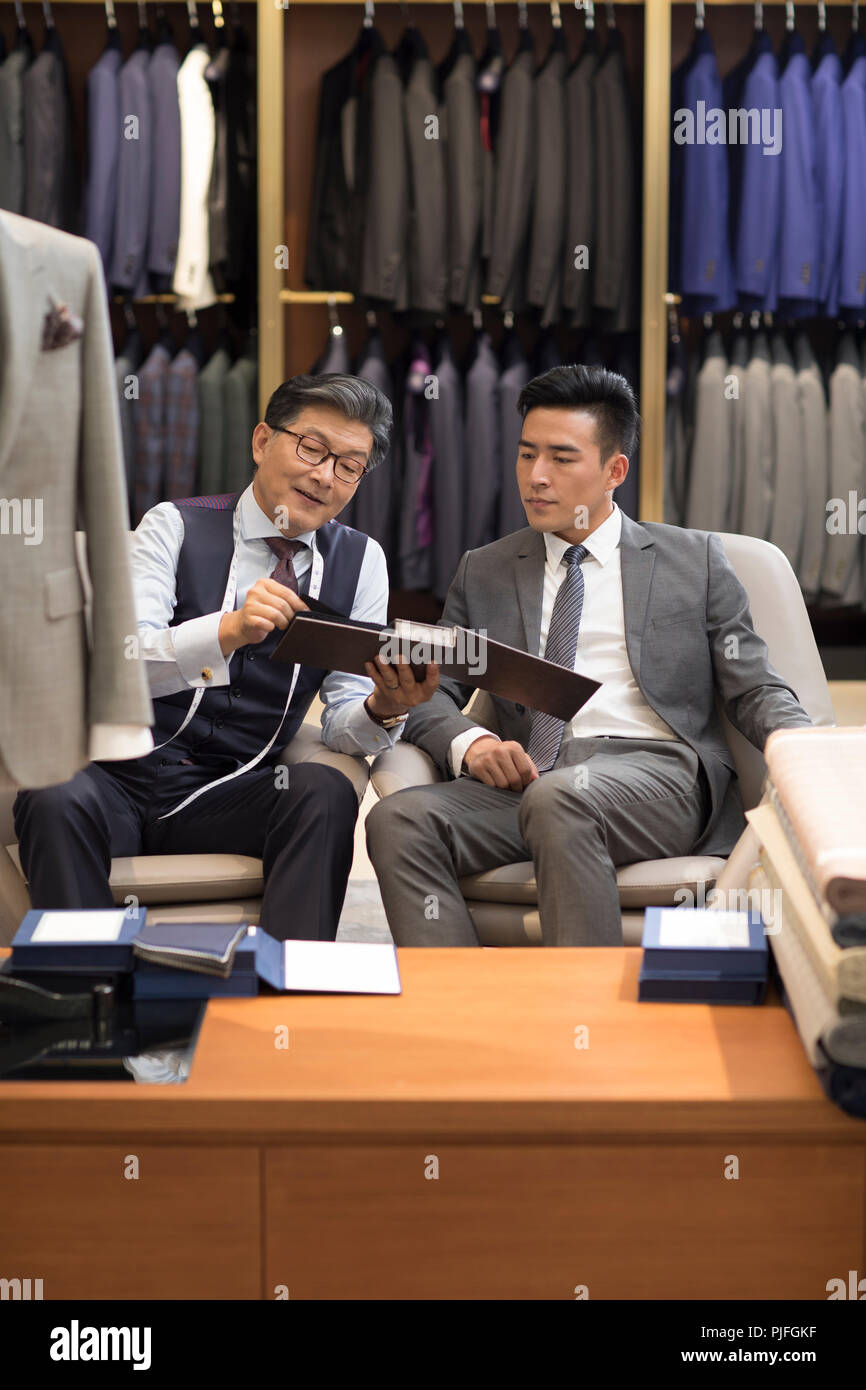 Diseñador de moda y hablar al cliente en la tienda de ropa de hombre  Fotografía de stock - Alamy