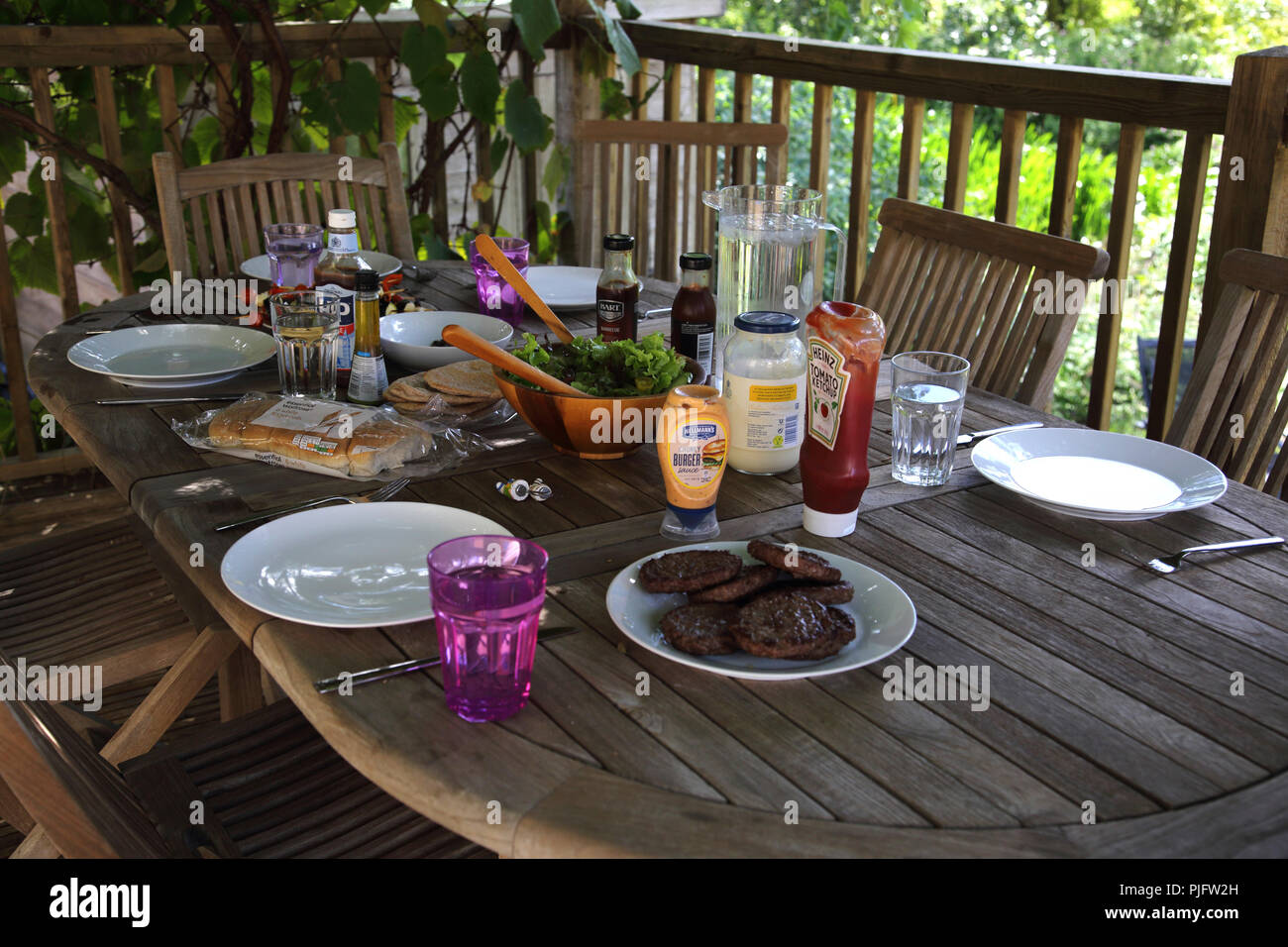 Juego de mesa para barbacoa, hamburguesas, ensaladas, brochetas y condimentos Foto de stock
