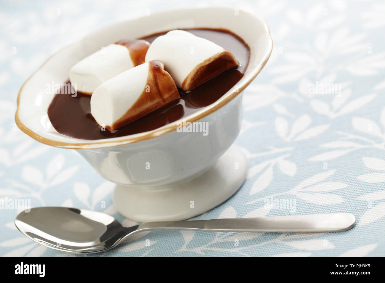 Chocolate caliente con malvavisco blanco en el recipiente Foto de stock