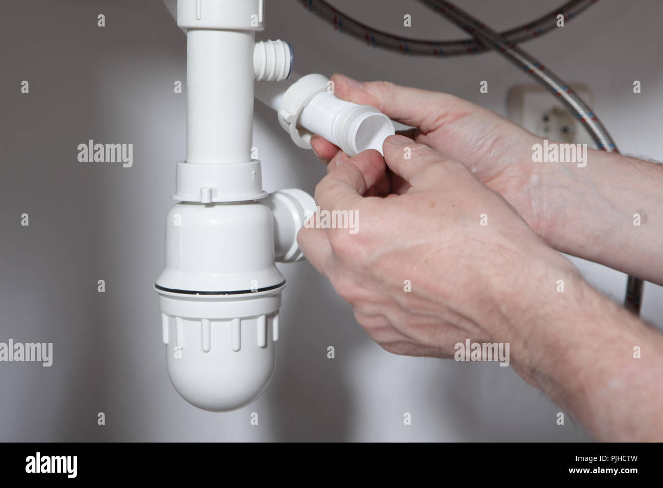 Fontanero instalar una arandela de goma para las tuberías de desagüe de un  drenaje para un fregadero Fotografía de stock - Alamy
