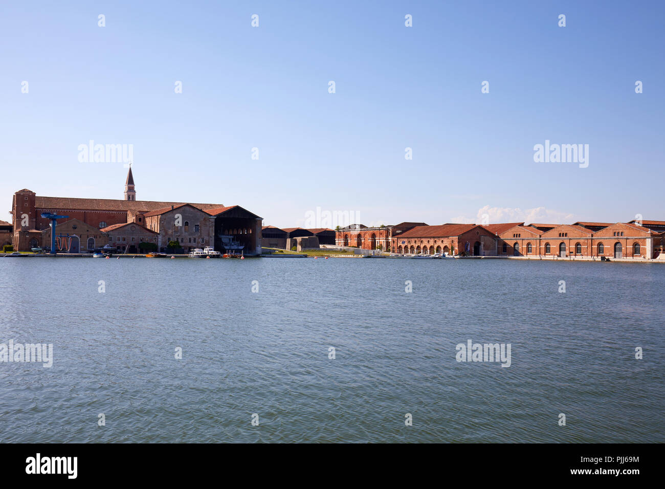 Arsenal veneciano astillero, canal industrial y edificios de ladrillo rojo en un día soleado en Venecia, Italia Foto de stock