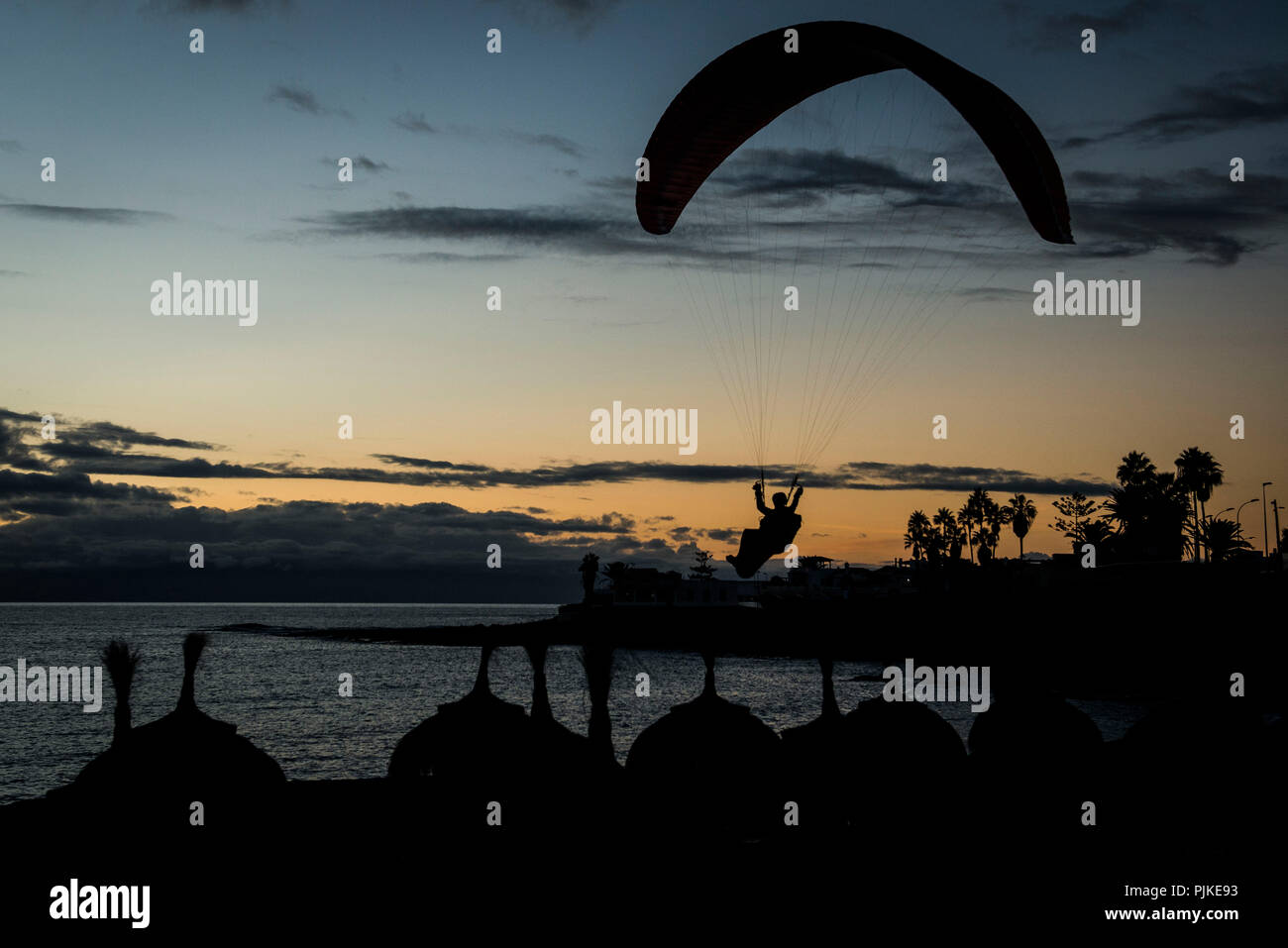 Parapente, al anochecer, aterrizando en el bar de la playa, la costa oeste de Tenerife, en La Caleta, isla volcánica, vista aérea, Islas Canarias, España Foto de stock