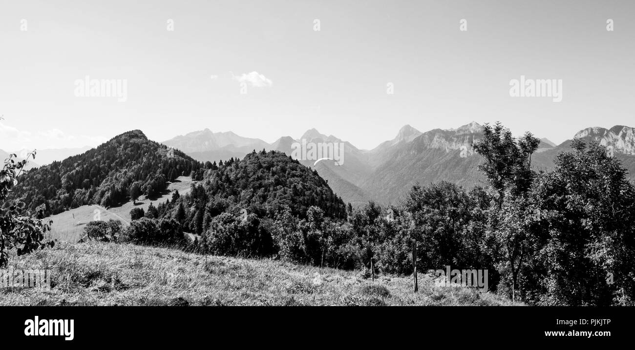 Panorama de montaña en blanco y negro, día de verano con parapente Foto de stock