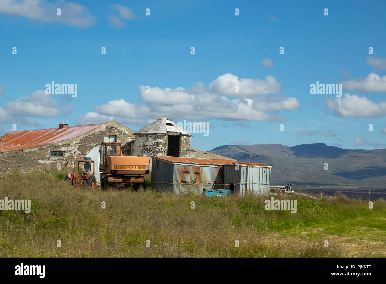 Islandia, granja abandonada, chatarra, estable, silo, excavadora, cielo azul, Foto de stock