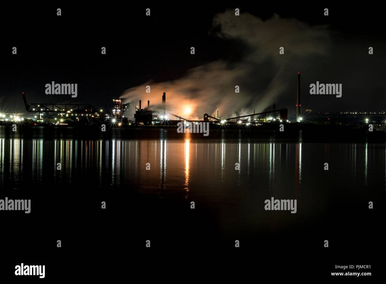 Las fábricas contaminantes y aumentar el calentamiento global. Ocupado en la acería industrial bombeo nocturno de humo en el medio ambiente. Time lapse vid Foto de stock