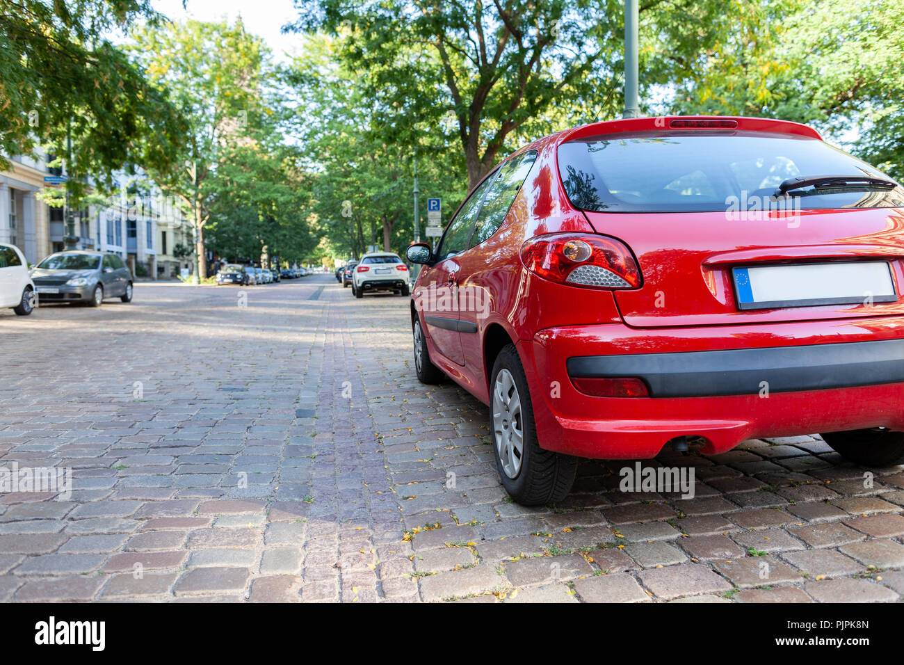 Un coche rojo está en una calle Foto de stock