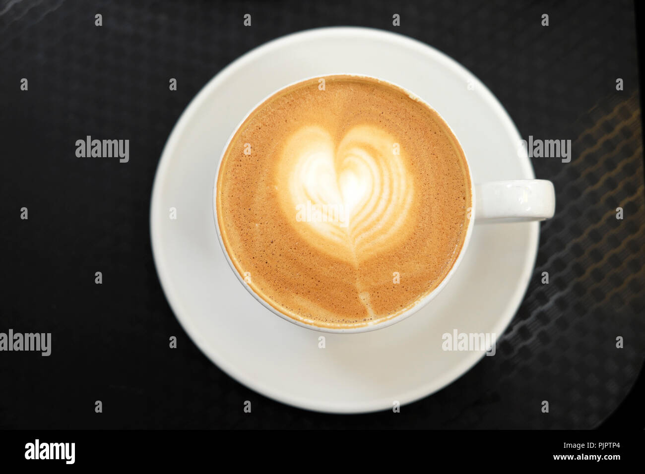Vista aérea de una taza de café lechoso espumosa con diseño en forma de corazón KATHY DEWITT Foto de stock