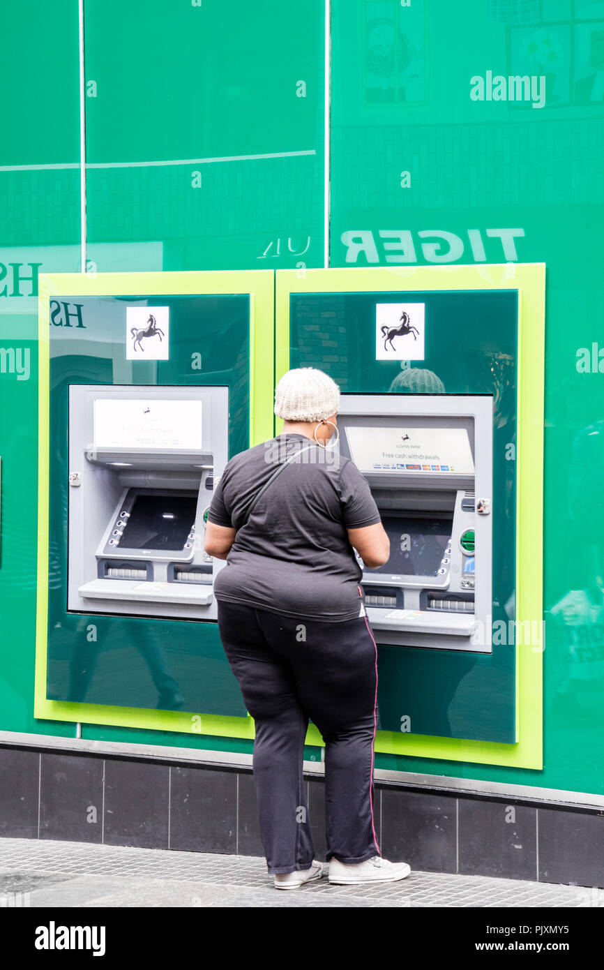 Señora utilizando una máquina de efectivo de Lloyds Bank, Bristol, Inglaterra, Reino Unido. Foto de stock