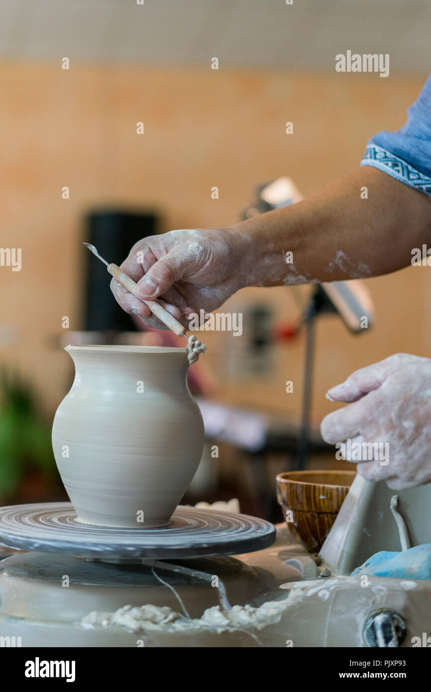 El Alfarero Moldea Una Vasija De Arcilla En Un Torno De Alfarero Las Manos Del Maestro Hacer Una Olla En El Torno De Alfarero Fotografia Vertical Fotografia De Stock Alamy