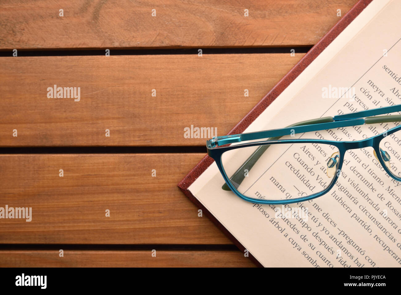 Gafas de lectura sobre la mesa de madera con libro abierto encima. Concepto  necesitan anteojos para leer. Vista desde arriba. Composición horizontal  Fotografía de stock - Alamy