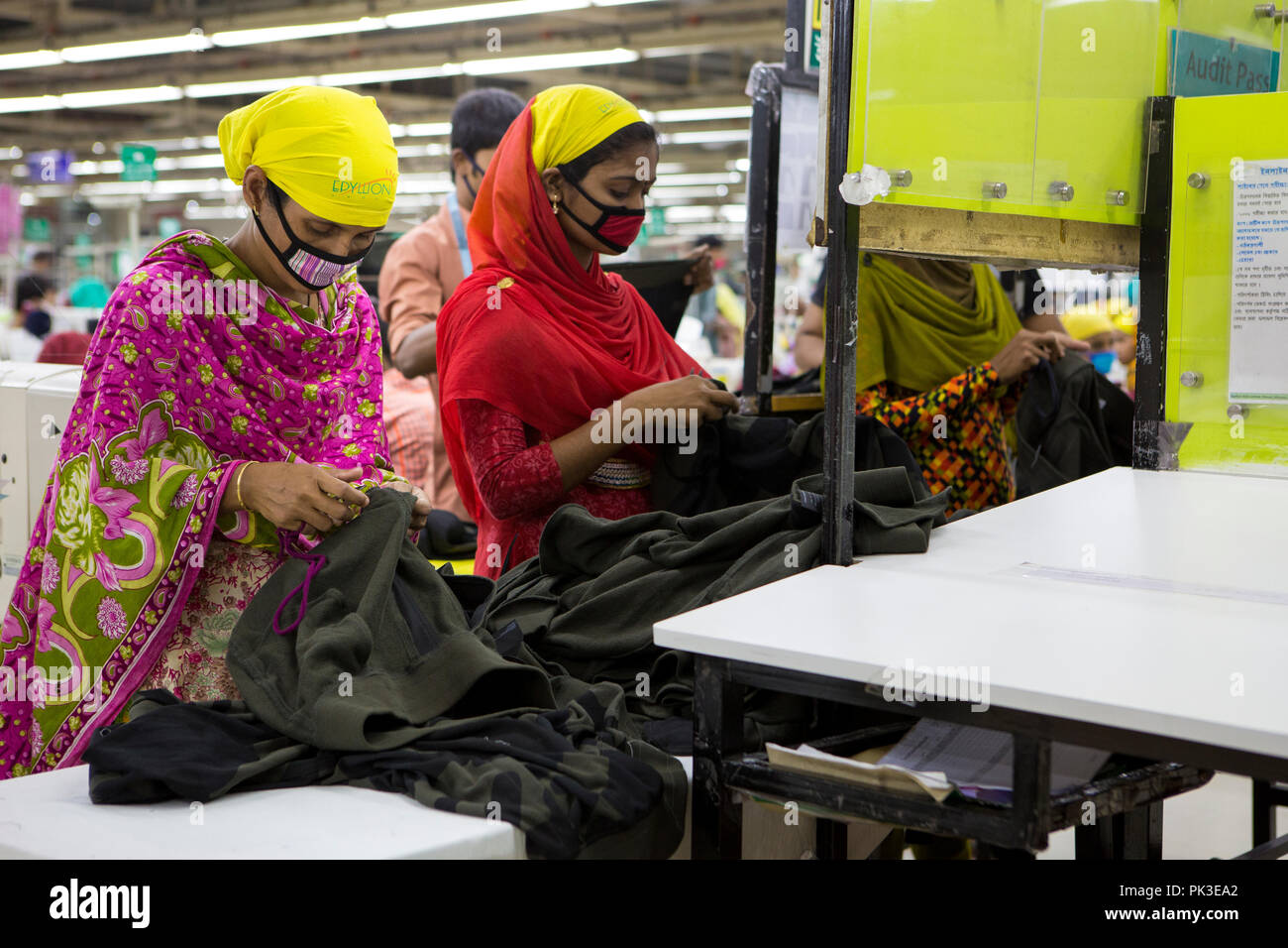Los trabajadores de la industria del vestido en el trabajo en la línea de  producción dentro de una fábrica de ropa en Bangladesh Fotografía de stock  - Alamy