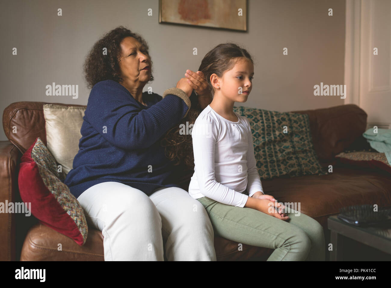 La abuela está haciendo el peinado de nieta Foto de stock