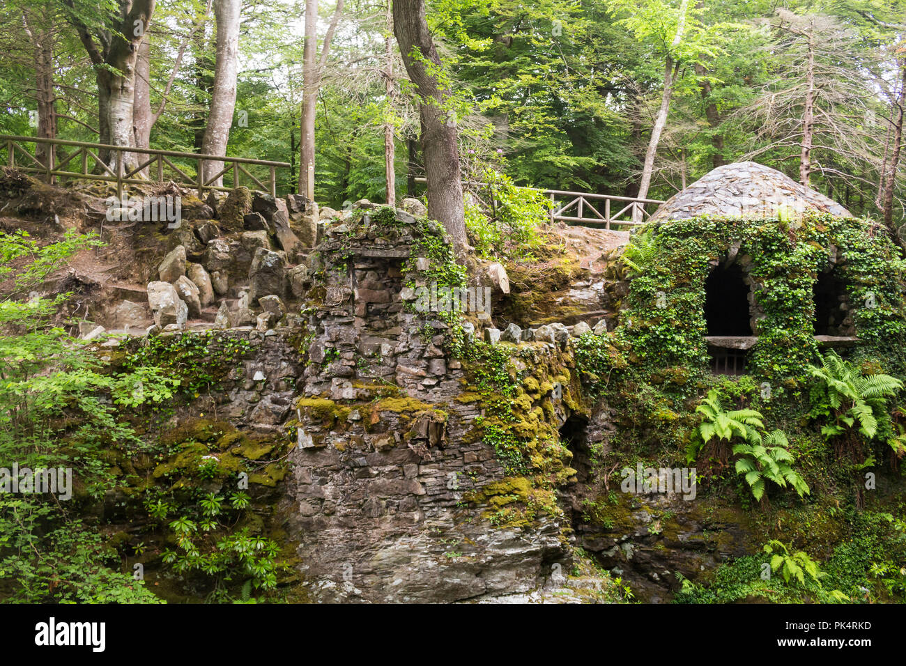 La ermita en Tollymore Park, es un bonito refugio de piedra cubierto de hiedra en un paseo junto al río Shima, Newcastle, Condado de Down, N. Foto de stock