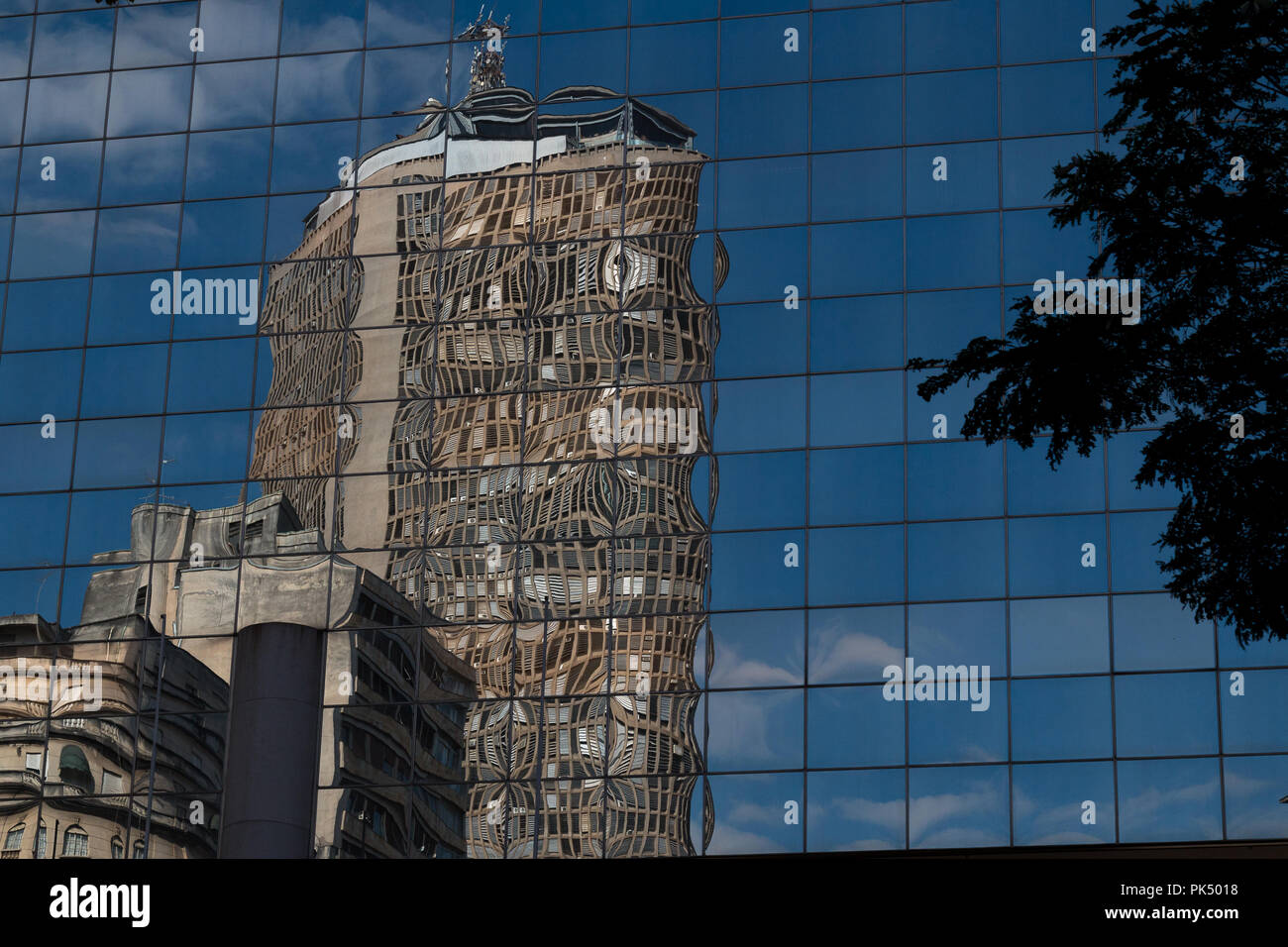 Skycraper reflejado en la fachada de vidrio de otro edificio. Foto de stock