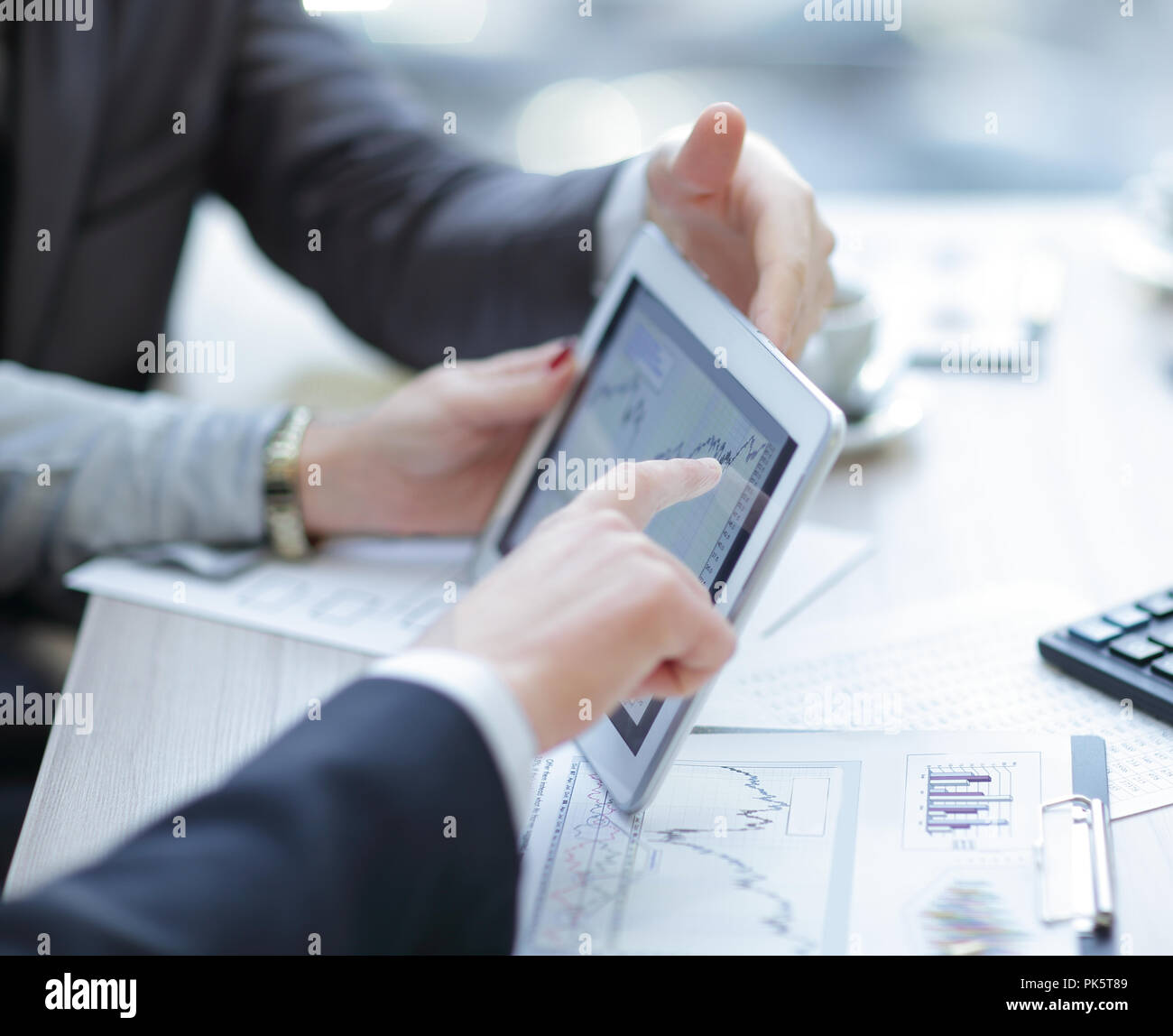 Close up.Equipo empresarial discutiendo gráficos financieros mediante tableta digital. Foto de stock