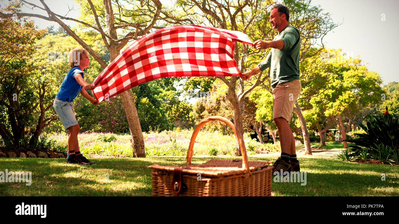 Padre e hijo extendiendo la manta para picnic Foto de stock