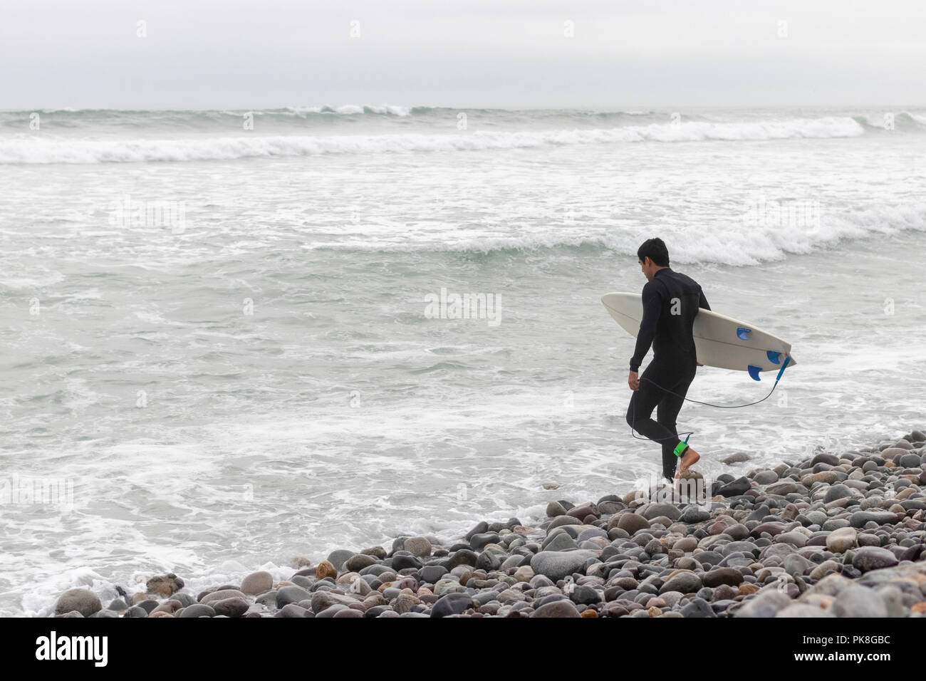 Hombre de entrar al agua a surfear Foto de stock