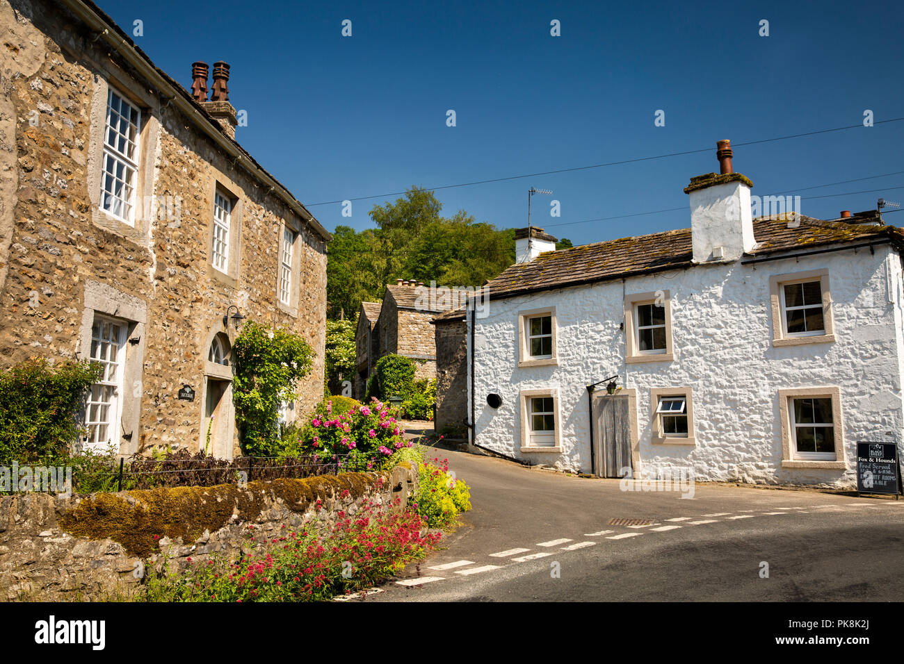 Reino Unido, Yorkshire, Wharfedale, casa Beckside Starbotton, siembra de flores blancas y Fox and Hounds pub Foto de stock